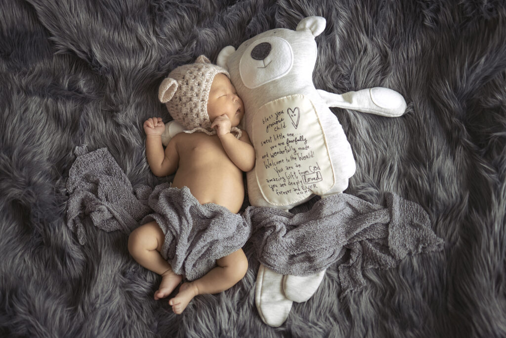 newborn baby girl or boy on shag rug with teddy bear